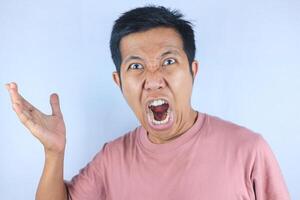 angry facial expression of asian man while making strong hand gesture, isolated on white background photo