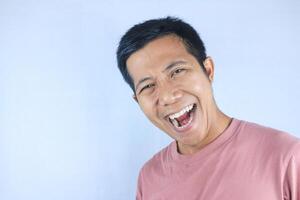 Laughing facial expression young asian man happy looking at camera, isolated on white background photo