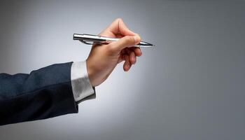 Close-up of a hand holding a pen, ready to write on something out of frame photo