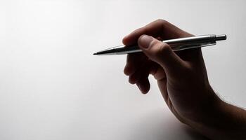Close-up of a hand holding a pen, ready to write on something out of frame photo