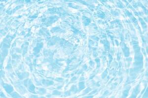 Blue water with ripples on the surface. Defocus blurred transparent blue colored clear calm water surface texture with splashes and bubbles. Water waves with shining pattern texture background. photo