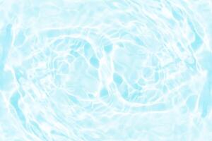 Blue water with ripples on the surface. Defocus blurred transparent blue colored clear calm water surface texture with splashes and bubbles. Water waves with shining pattern texture background. photo