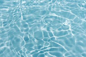 Blue water with ripples on the surface. Defocus blurred transparent blue colored clear calm water surface texture with splashes and bubbles. Water waves with shining pattern texture background. photo