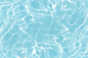 Bluewater waves on the surface ripples blurred. Defocus blurred transparent blue colored clear calm water surface texture with splash and bubbles. Water waves with shining pattern texture background. photo