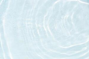 Blue water with ripples on the surface. Defocus blurred transparent blue colored clear calm water surface texture with splashes and bubbles. Water waves with shining pattern texture background. photo