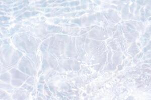 Blue water with ripples on the surface. Defocus blurred transparent blue colored clear calm water surface texture with splashes and bubbles. Water waves with shining pattern texture background. photo