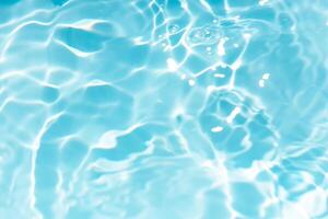 Bluewater waves on the surface ripples blurred. Defocus blurred transparent blue colored clear calm water surface texture with splash and bubbles. Water waves with shining pattern texture background. photo