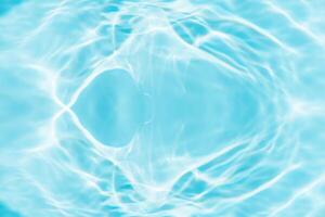 Bluewater waves on the surface ripples blurred. Defocus blurred transparent blue colored clear calm water surface texture with splash and bubbles. Water waves with shining pattern texture background. photo