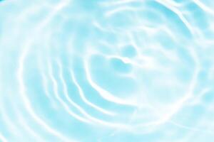 Bluewater waves on the surface ripples blurred. Defocus blurred transparent blue colored clear calm water surface texture with splash and bubbles. Water waves with shining pattern texture background. photo