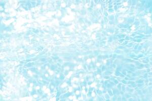 Bluewater waves on the surface ripples blurred. Defocus blurred transparent blue colored clear calm water surface texture with splash and bubbles. Water waves with shining pattern texture background. photo