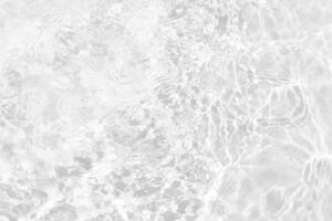 Blue water with ripples on the surface. Defocus blurred transparent blue colored clear calm water surface texture with splashes and bubbles. Water waves with shining pattern texture background. photo