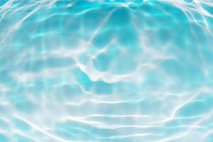 Bluewater waves on the surface ripples blurred. Defocus blurred transparent blue colored clear calm water surface texture with splash and bubbles. Water waves with shining pattern texture background. photo