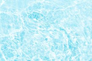 Blue water with ripples on the surface. Defocus blurred transparent blue colored clear calm water surface texture with splashes and bubbles. Water waves with shining pattern texture background. photo
