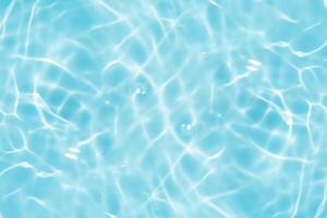 Bluewater waves on the surface ripples blurred. Defocus blurred transparent blue colored clear calm water surface texture with splash and bubbles. Water waves with shining pattern texture background. photo