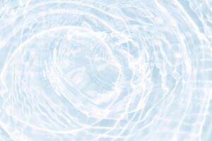 Bluewater waves on the surface ripples blurred. Defocus blurred transparent blue colored clear calm water surface texture with splash and bubbles. Water waves with shining pattern texture background. photo