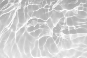 Blue water with ripples on the surface. Defocus blurred transparent blue colored clear calm water surface texture with splashes and bubbles. Water waves with shining pattern texture background. photo