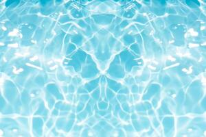 Blue water with ripples on the surface. Defocus blurred transparent blue colored clear calm water surface texture with splashes and bubbles. Water waves with shining pattern texture background. photo