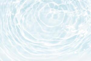 Blue water with ripples on the surface. Defocus blurred transparent blue colored clear calm water surface texture with splashes and bubbles. Water waves with shining pattern texture background. photo