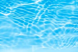 Blue water with ripples on the surface. Defocus blurred transparent blue colored clear calm water surface texture with splashes and bubbles. Water waves with shining pattern texture background. photo