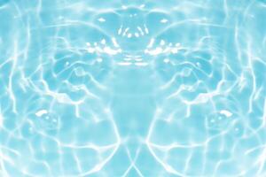 Blue water with ripples on the surface. Defocus blurred transparent blue colored clear calm water surface texture with splashes and bubbles. Water waves with shining pattern texture background. photo