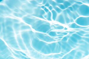 Blue water with ripples on the surface. Defocus blurred transparent blue colored clear calm water surface texture with splashes and bubbles. Water waves with shining pattern texture background. photo