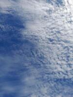 Beautiful white clouds on deep blue sky background. Large bright soft fluffy clouds are cover the entire blue sky. photo