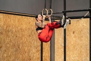 Woman training using olympic rings alone in a gym photo