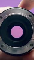 Close-up of man rotating lens. Action. Photographer turns ring of professional lens on isolated background. Lens of lens changes size from rotation of ring by photographer video