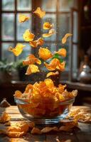 A bowl of chips is flying through the air. The bowl is full of chips and the chips are scattered all over the table photo