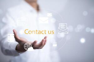 Communication and Contact us or Customer support hotline people connect. Hand using a laptop and touching on virtual screen contact icons, email and address, live chat with internet wifi. photo