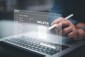 The programmer's hand is tapping on the file icon under the concept of data deletion. The concept technology and document management.data deletion and removal photo