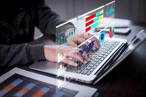 Businessman using a laptop with Analytics and Data Management Systems Analyst working in Business Analytics and Data Management Systems to make reports and corporate strategy for finance, operations photo