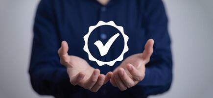 Quality assurance of business services, Businessman Hand shows the sign of the top service Quality assurance in Black background , Guarantee, Standards, ISO certification and standardization concept. photo