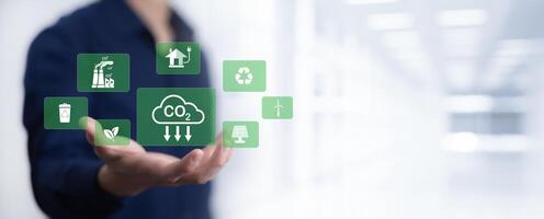 Businessman hand hold recycle symbol connection with virtual modern reduce CO2 emission concept with icons, global warming emissions carbon footprint climate change to limit global warming, energy photo