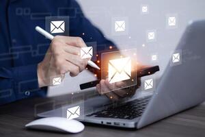 Businessman sending email by laptop computer to customer, business contact and communication, email icon, email marketing concept, send e-mail or newsletter, online working internet network. photo