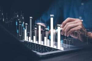 businessman hand type on the laptop of company profit with colleagues partner explain with virtual dashboard statistic chart stock infographic, graphs, cryptocurrency, and new trading platforms photo