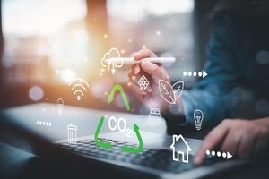 Businessman using laptops and touch recycle symbol with virtual modern reduce CO2 emission concept with icons, global warming emissions carbon footprint climate change to limit global warming, energy photo