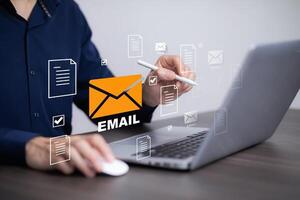 Businessman sending email by laptop computer to customer, business contact and communication, email icon, email marketing concept, send e-mail or newsletter, online working internet network. photo