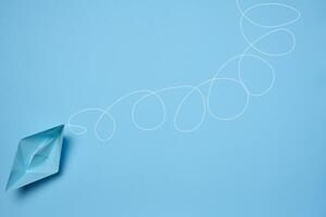 Blue paper boat and a long tangled path, symbolizing the concept of a challenging journey photo