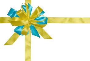 A yellow satin bow tied at the intersection of two ribbons. A yellow tag is attached to the bow. Isolated background photo