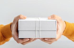 a person holding a white gift box photo