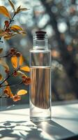 Elegant glass bottle with liquid, backlit by sunlight with autumn leaves, creating a serene and warm atmosphere. photo