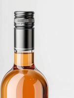 Close-up of a clear glass bottle with a metal screw cap filled with amber liquid against a white background. photo