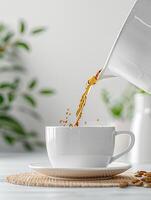 Pouring fresh tea into a white cup on a woven mat, with a blurred green plant background, perfect for refreshing morning start. photo