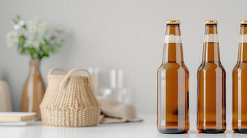 Three brown beer bottles on a white kitchen counter with a woven basket, glass jars, and a vase with flowers in the background. photo