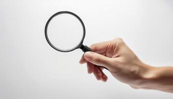Hand holding magnifying glass isolated on white background, symbolizing search, investigation, and magnification concepts. photo