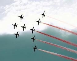 Airshow of military jet fighters. Group of military airplanes performs maneuvers with a smoke trace. Aviation background photo