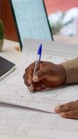 Vertical Corporate owner measuring and evaluating office blueprints and architectural sketches, working on strategy planning for a modern and professional workspace design. Relocate office space. Camera A. video