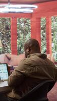 Vertical Entrepreneur reviewing statistics data on a laptop remotely from his house, makes a briefing report. Business owner studying sales numbers and the profit to increase organizational funds. Camera B. video
