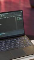 Vertical AI software developer creating an algorithm for deep learning and data mining, coding on his laptop at home office. Expert processing binary code on supercomputer neural network. Camera A. video